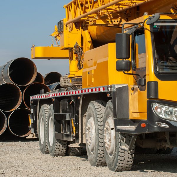 A side shot of a yellow crane in an industrial construction area